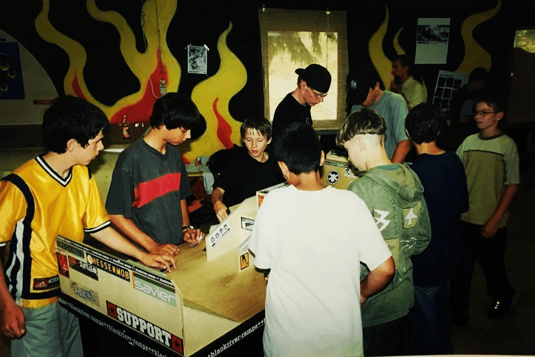 Archival Fast Fingers riders gathered around an event table.