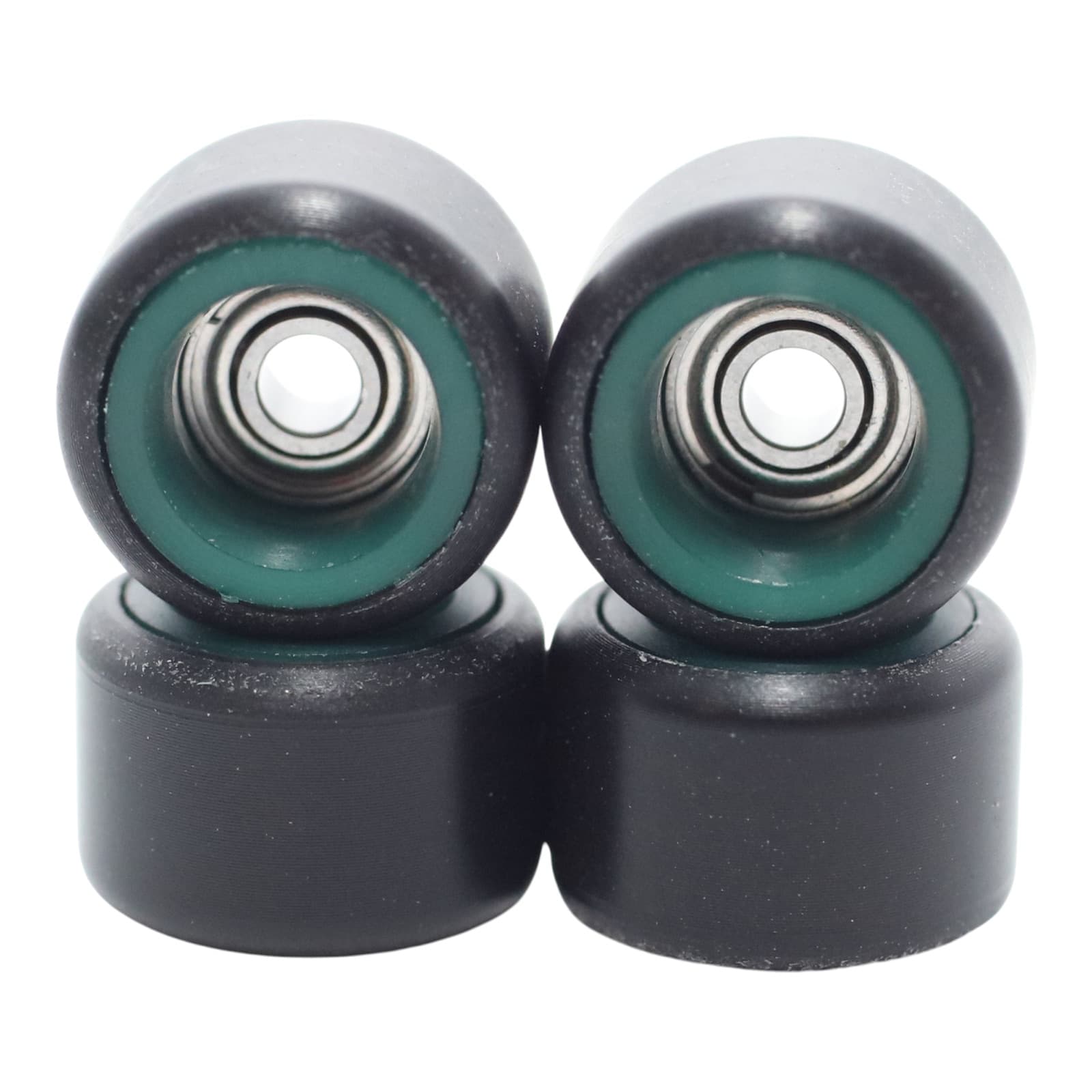 FlatFace dual-durometer bearing wheels in black over green cores, macro shot.