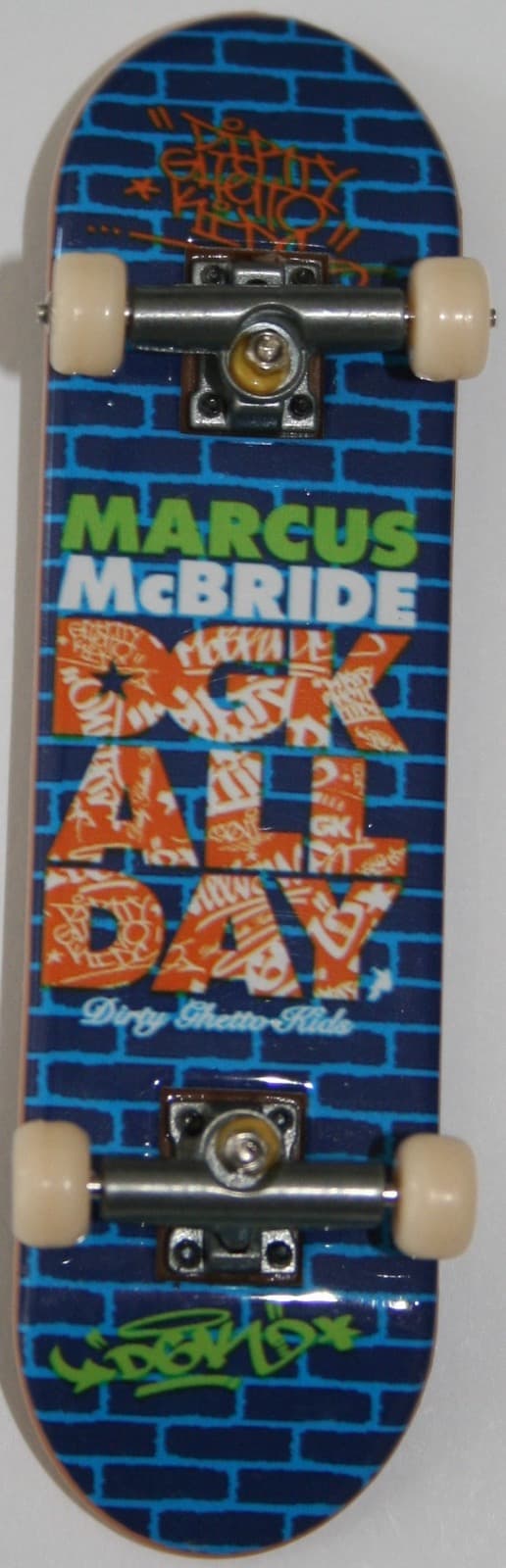A Tech Deck DGK Marcus McBride pro-model complete with a blue brick graphic, photographed top-down.