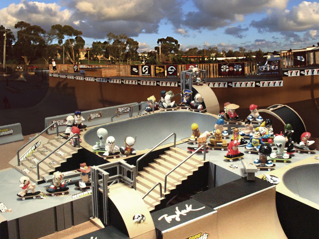Official 2002 Tech Deck key art of Tech Deck Dudes figures riding a miniature skatepark under dramatic clouds.