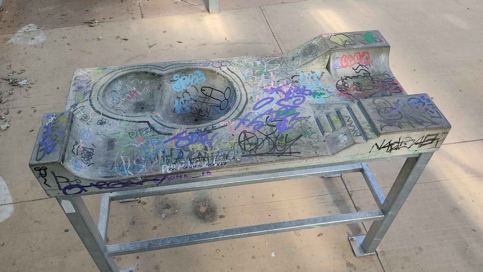 A purpose-built fingerskate practice table with obstacles at a skatepark.