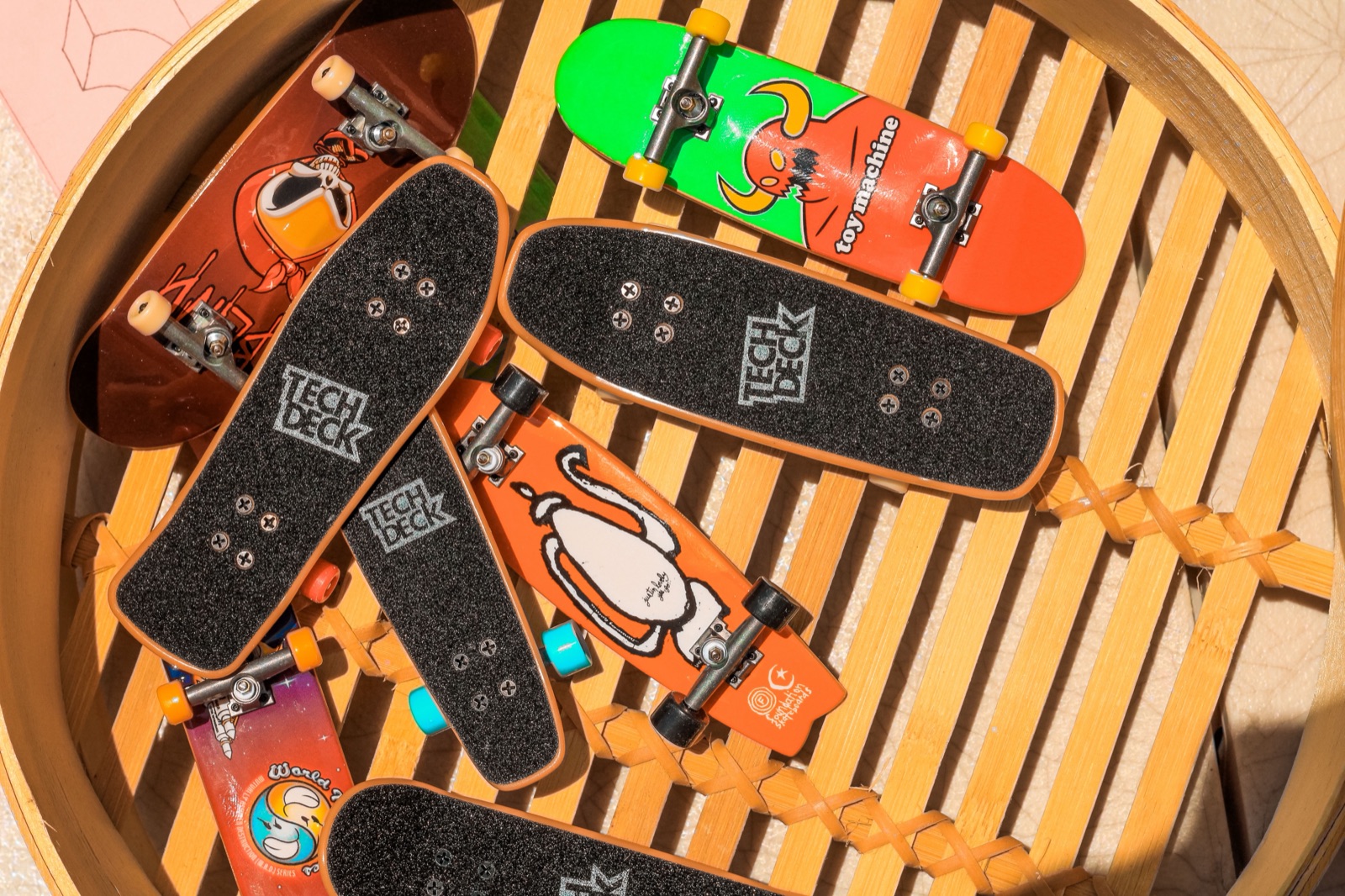 Colorful miniature fingerboard skateboards collected together in a basket.